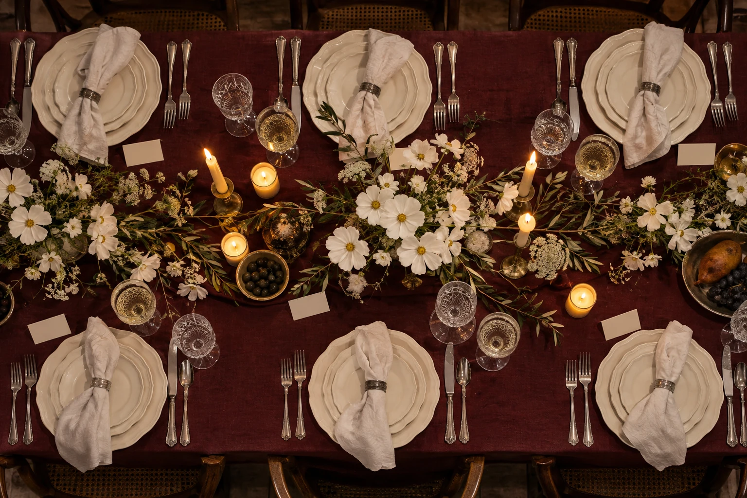 Burgundy linen, crystal glasses and flowers on a long wedding table
